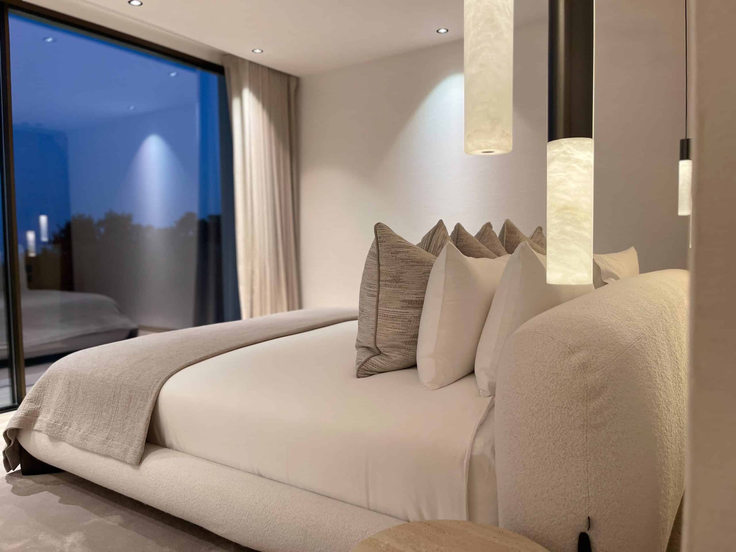 Softly layered bedroom overlooking the coast