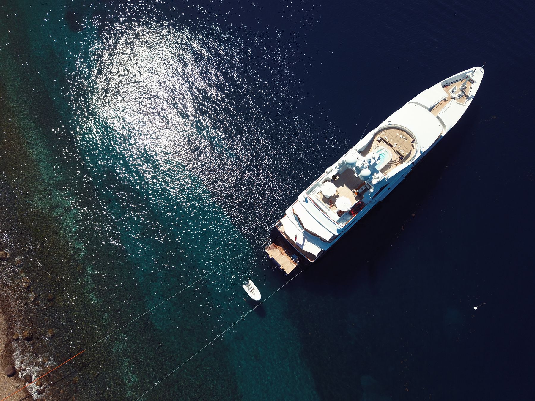 Aerial view of MY Helios at anchor in clear water